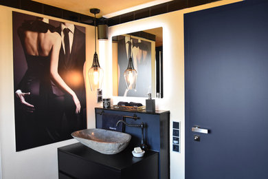 Mittelgroßes Modernes Duschbad mit Granit-Waschbecken/Waschtisch, schwarzen Schränken, bodengleicher Dusche, Wandtoilette mit Spülkasten, bunten Wänden, Keramikboden und Aufsatzwaschbecken in Köln