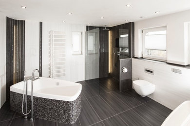 ドルトムントにある高級な中くらいなコンテンポラリースタイルのおしゃれなバスルーム (浴槽なし) (ベッセル式洗面器、白いキャビネット、置き型浴槽、バリアフリー、分離型トイレ、グレーのタイル、セラミックタイル、白い壁、セラミックタイルの床) の写真