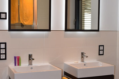 Großes Modernes Duschbad mit flächenbündigen Schrankfronten, dunklen Holzschränken, beigen Fliesen, Keramikfliesen, Aufsatzwaschbecken und Glaswaschbecken/Glaswaschtisch in Stuttgart