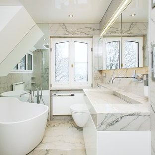 Mittelgroßes Klassisches Duschbad mit flächenbündigen Schrankfronten, weißen Schränken, freistehender Badewanne, Nasszelle, Wandtoilette, schwarz-weißen Fliesen, Marmorfliesen, weißer Wandfarbe, Marmorboden, Trogwaschbecken, Marmor-Waschbecken/Waschtisch und Falttür-Duschabtrennung in Sonstige
