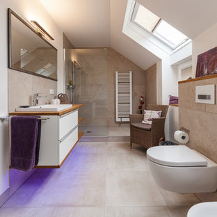 Mittelgroßes Modernes Duschbad mit Schrankfronten mit vertiefter Füllung, weißen Schränken, offener Dusche, Wandtoilette mit Spülkasten, beigefarbenen Fliesen, weißer Wandfarbe, Einbauwaschbecken, Waschtisch aus Holz, beigem Boden, offener Dusche und brauner Waschtischplatte in Sonstige