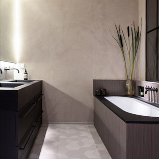 Großes Industrial Badezimmer En Suite mit flächenbündigen Schrankfronten, dunklen Holzschränken, Unterbauwanne, bodengleicher Dusche, Wandtoilette, Stäbchenfliesen, grauer Wandfarbe, Mosaik-Bodenfliesen, integriertem Waschbecken, Granit-Waschbecken/Waschtisch, grauem Boden, offener Dusche, schwarzer Waschtischplatte, Nische, Doppelwaschbecken, freistehendem Waschtisch und eingelassener Decke in Hamburg