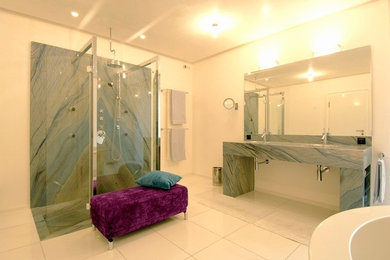 Ejemplo de cuarto de baño contemporáneo con bañera exenta, ducha empotrada, baldosas y/o azulejos azules, baldosas y/o azulejos de piedra y suelo de mármol