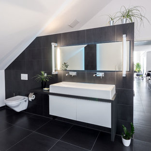 Mittelgroßes Modernes Badezimmer En Suite mit flächenbündigen Schrankfronten, weißen Schränken, Wandtoilette mit Spülkasten, schwarzen Fliesen, weißen Fliesen, weißer Wandfarbe, schwarzem Boden und schwarzer Waschtischplatte in Stuttgart