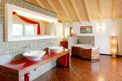 Inspiration pour une très grande salle de bain bohème avec une baignoire d'angle, un carrelage multicolore, un mur blanc, parquet foncé, des carreaux de céramique, une vasque et un plan de toilette en bois.