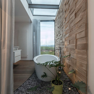 Mittelgroßes Modernes Badezimmer En Suite mit flächenbündigen Schrankfronten, weißen Schränken, freistehender Badewanne, weißer Wandfarbe, braunem Holzboden, Aufsatzwaschbecken und braunem Boden in Stuttgart