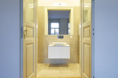 Mittelgroßes Modernes Badezimmer En Suite mit flächenbündigen Schrankfronten, weißen Schränken, beigen Fliesen, Steinfliesen und Quarzwerkstein-Waschtisch in München