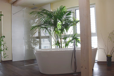 Großes Modernes Badezimmer mit freistehender Badewanne, bodengleicher Dusche, weißer Wandfarbe, beigen Fliesen, braunem Boden und offener Dusche in Nürnberg