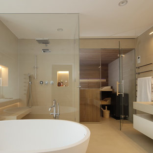 Großes Modernes Badezimmer mit flächenbündigen Schrankfronten, beigen Schränken, freistehender Badewanne, bodengleicher Dusche, beigefarbenen Fliesen, Zementfliesen, beiger Wandfarbe, Zementfliesen, Sauna, Aufsatzwaschbecken, Beton-Waschbecken/Waschtisch, beigem Boden und Falttür-Duschabtrennung in Sonstige