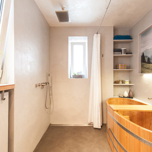 Mittelgroßes Modernes Badezimmer En Suite mit japanischer Badewanne, Nasszelle, grauer Wandfarbe, offenen Schränken, Betonboden, grauem Boden und Duschvorhang-Duschabtrennung in Stuttgart