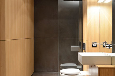 Imagen de cuarto de baño contemporáneo pequeño con armarios con paneles lisos, puertas de armario de madera oscura, ducha empotrada, sanitario de pared, baldosas y/o azulejos grises, aseo y ducha, lavabo sobreencimera y encimera de madera