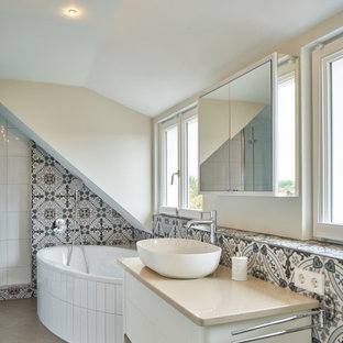 Maritimes Badezimmer mit flächenbündigen Schrankfronten, weißen Schränken, freistehender Badewanne, farbigen Fliesen, grauer Wandfarbe, Aufsatzwaschbecken, grauem Boden, beiger Waschtischplatte, Einzelwaschbecken und freistehendem Waschtisch in Stuttgart