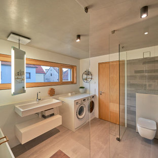 Modernes Badezimmer mit flächenbündigen Schrankfronten, weißen Schränken, freistehender Badewanne, bodengleicher Dusche, grauen Fliesen, weißer Wandfarbe, Aufsatzwaschbecken, grauem Boden, offener Dusche, Einzelwaschbecken und schwebendem Waschtisch in Nürnberg