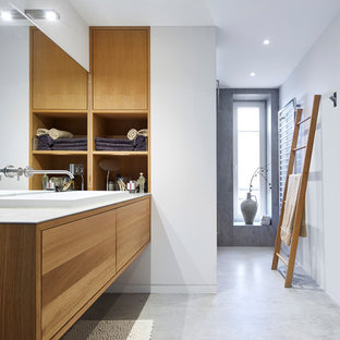Immagine di una grande stanza da bagno padronale contemporanea con ante lisce, ante in legno scuro, pareti bianche, pavimento in cemento, lavabo a bacinella, pavimento grigio, piastrelle bianche, piastrelle a specchio, top in vetro, top grigio e doccia a filo pavimento