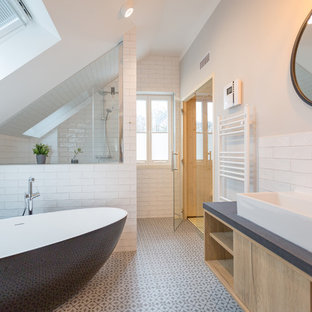 Großes Modernes Duschbad mit flächenbündigen Schrankfronten, hellen Holzschränken, freistehender Badewanne, weißen Fliesen, Keramikboden, Aufsatzwaschbecken, Metrofliesen, offener Dusche, Nasszelle, beiger Wandfarbe, weißem Boden und grauer Waschtischplatte in Berlin