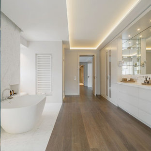 Geräumiges Modernes Duschbad mit flächenbündigen Schrankfronten, grauen Schränken, freistehender Badewanne, offener Dusche, grauen Fliesen, weißen Fliesen, grauer Wandfarbe, Unterbauwaschbecken, braunem Boden, grauer Waschtischplatte, Nische, Doppelwaschbecken und eingebautem Waschtisch in Berlin
