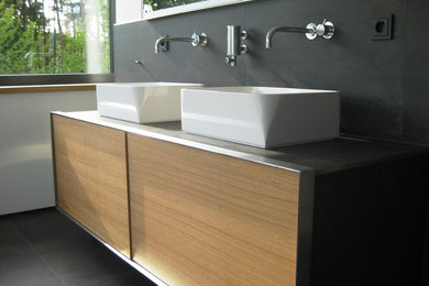 Modernes Badezimmer mit hellbraunen Holzschränken und gefliestem Waschtisch in Nürnberg