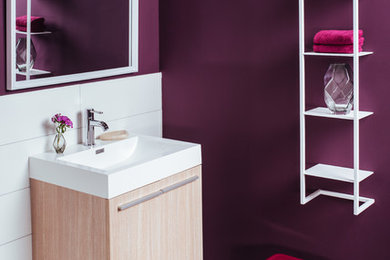 This is an example of a small contemporary shower room bathroom in Berlin with flat-panel cabinets, light wood cabinets, white tiles, purple walls, cement flooring, a built-in sink and brown floors.