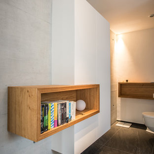 Mittelgroßes Modernes Badezimmer mit flächenbündigen Schrankfronten, weißen Schränken, Wandtoilette, weißer Wandfarbe und schwarzem Boden in Stuttgart