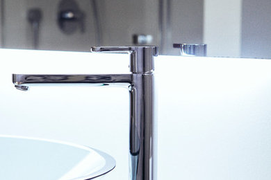 Mittelgroßes Modernes Duschbad mit Einbaubadewanne, Wandtoilette mit Spülkasten, weißen Fliesen, Steinfliesen, weißer Wandfarbe, Marmorboden, Aufsatzwaschbecken, beigem Boden, Falttür-Duschabtrennung und weißer Waschtischplatte in Frankfurt am Main