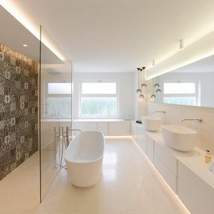 Großes Modernes Badezimmer En Suite mit freistehender Badewanne, bodengleicher Dusche, Keramikboden, Mineralwerkstoff-Waschtisch, offener Dusche, flächenbündigen Schrankfronten, weißen Schränken, farbigen Fliesen, weißer Wandfarbe, Aufsatzwaschbecken, weißem Boden und weißer Waschtischplatte in Stuttgart