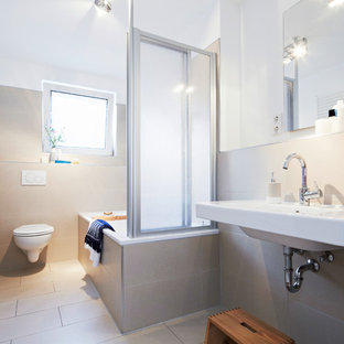 Kleines Modernes Duschbad mit Einbaubadewanne, Duschbadewanne, Wandtoilette, beigefarbenen Fliesen, Zementfliesen, weißer Wandfarbe, Zementfliesen, Wandwaschbecken, beigem Boden und Falttür-Duschabtrennung in Nürnberg
