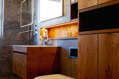 Mittelgroßes Modernes Duschbad mit flächenbündigen Schrankfronten, hellbraunen Holzschränken, offener Dusche, Wandtoilette, Einbauwaschbecken und offener Dusche in München