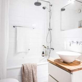 Modern inredning av ett litet beige beige badrum med dusch, med släta luckor, vita skåp, ett fristående badkar, en dusch i en alkov, vit kakel, porslinskakel, klinkergolv i porslin, ett fristående handfat, träbänkskiva, grått golv och dusch med duschdraperi