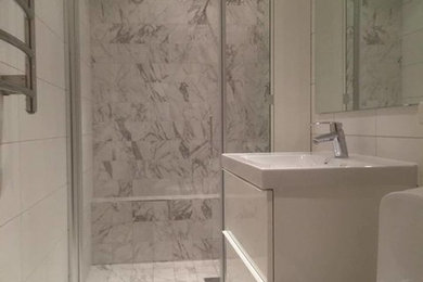 Modern inredning av ett mellanstort badrum med dusch, med grå kakel
