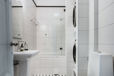 Bild på ett mellanstort vintage badrum med dusch, med ett platsbyggt badkar, en hörndusch, en toalettstol med separat cisternkåpa, vit kakel, vita väggar, cementgolv, ett fristående handfat, vitt golv och dusch med gångjärnsdörr