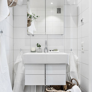 Idéer för att renovera ett litet skandinaviskt badrum, med släta luckor, vita skåp, vit kakel, vita väggar och svart golv