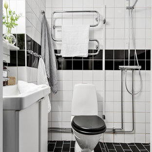 Inspiration för ett skandinaviskt badrum med dusch, med släta luckor, vita skåp, en öppen dusch, en toalettstol med separat cisternkåpa, svart och vit kakel, vita väggar, svart golv och med dusch som är öppen