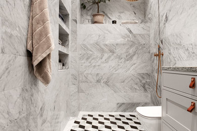 Skandinavisk inredning av ett mellanstort badrum, med luckor med infälld panel, grå skåp, en öppen dusch, grå kakel och flerfärgat golv