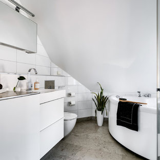 Idéer för minimalistiska grått en-suite badrum, med släta luckor, vita skåp, en jacuzzi, vit kakel, vita väggar, ett integrerad handfat, bänkskiva i rostfritt stål och grått golv