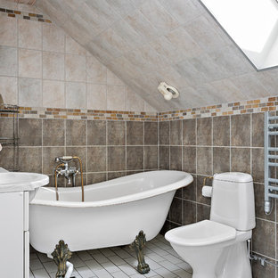 Inredning av ett lantligt litet grå grått badrum med dusch, med vita skåp, ett badkar med tassar, en dusch/badkar-kombination, en toalettstol med hel cisternkåpa, beige kakel, brun kakel, vitt golv, flerfärgade väggar, ett integrerad handfat och med dusch som är öppen