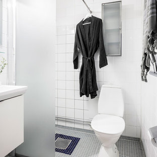 Idéer för att renovera ett minimalistiskt vit vitt badrum med dusch, med släta luckor, vita skåp, en hörndusch, en toalettstol med hel cisternkåpa, vit kakel, vita väggar, mosaikgolv, ett konsol handfat, grått golv och med dusch som är öppen