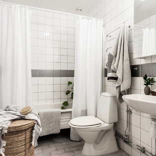 Bild på ett minimalistiskt badrum med dusch, med öppna hyllor, ett fristående badkar, en dusch/badkar-kombination, en toalettstol med separat cisternkåpa, grå kakel, vit kakel, porslinskakel, vita väggar, tegelgolv, ett väggmonterat handfat, grått golv och dusch med duschdraperi