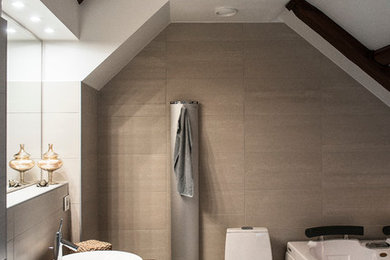 Exempel på ett mellanstort modernt badrum, med släta luckor, skåp i mörkt trä, ett hörnbadkar, en vägghängd toalettstol, beige kakel, stenkakel, beige väggar, klinkergolv i keramik, ett piedestal handfat och träbänkskiva