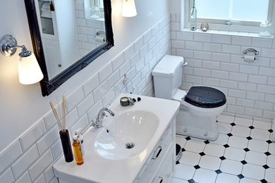 Exempel på ett mellanstort klassiskt badrum med dusch, med luckor med profilerade fronter, vita skåp, vit kakel och ett avlångt handfat