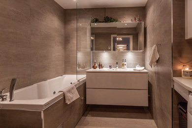 Foto på ett stort funkis badrum, med släta luckor, vita skåp, ett badkar i en alkov, brun kakel, bruna väggar, ett konsol handfat, en dusch/badkar-kombination, keramikplattor, klinkergolv i keramik och med dusch som är öppen