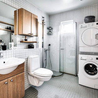 Idéer för minimalistiska badrum, med släta luckor, skåp i mellenmörkt trä, en hörndusch, vit kakel, mosaik, ett nedsänkt handfat och grått golv