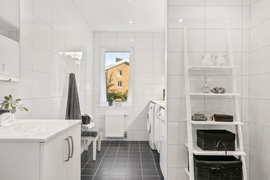 Idéer för ett skandinaviskt badrum, med släta luckor, vita skåp, vit kakel och svart golv