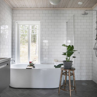 Idéer för att renovera ett minimalistiskt vit vitt en-suite badrum, med släta luckor, grå skåp, ett fristående badkar, en kantlös dusch, vit kakel, tunnelbanekakel, ett nedsänkt handfat, grått golv och dusch med gångjärnsdörr