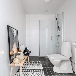 Exempel på ett minimalistiskt badrum med dusch, med vita skåp, våtrum, en toalettstol med separat cisternkåpa, vit kakel, keramikplattor, vita väggar och svart golv