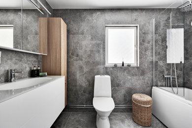 Idéer för ett modernt vit badrum, med släta luckor, vita skåp, grå kakel, ett integrerad handfat och grått golv
