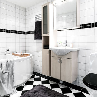 Exempel på ett mellanstort klassiskt en-suite badrum, med släta luckor, beige skåp, vita väggar, flerfärgat golv, ett fristående badkar, en toalettstol med hel cisternkåpa, svart och vit kakel och ett konsol handfat