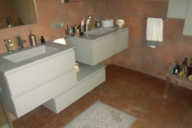 Réalisation d'un petit WC et toilettes design avec des portes de placard grises, un mur multicolore et un sol multicolore.