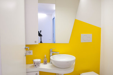 Immagine di un piccolo bagno di servizio contemporaneo con ante lisce, ante bianche, WC monopezzo, pareti grigie, lavabo a bacinella, top in laminato e pavimento marrone