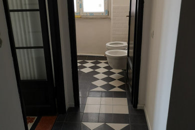 Idee per un piccolo bagno di servizio minimalista con WC a due pezzi, piastrelle bianche, piastrelle in ceramica, pareti bianche, pavimento con piastrelle in ceramica, lavabo a colonna e pavimento multicolore