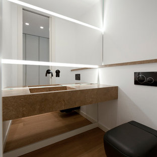 Idee per un bagno di servizio minimalista con pareti bianche, pavimento in legno massello medio, lavabo integrato e top beige